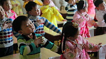 School children practicing singing and dancing in a classroom, Pyongyang, Democratic Peoples' Republic of Korea (DPRK), 2012.