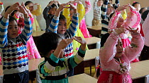 School children practicing singing and dancing in a classroom, Pyongyang, Democratic Peoples' Republic of Korea (DPRK), 2012.