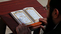 Man rocking back and forth shuckeling whilst reading a prayer book at the Wailing Wall, Jerusalem, Israel, 2011.