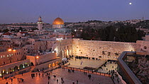View overlooking people praying at the Wailing Wall, with the Dome of the Rock illuminated in the background, Temple Mount, Jerusalem, Israel, 2011.