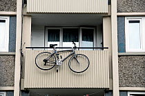 Bicycle / bike hanging from balcony of a block of urban council flats, London Borough of Islington, England UK, June 2010