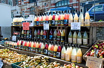 Bottles of organic juice alongside local apples and pears on sale at Marylebone Farmers Market, London, England, UK, March 2009