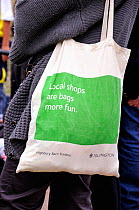 Reusable cotton bag promoting local shops with &#39;Local shops are bags more fun&#39; printed on the side, Highbury Barn Traders, London Borough of Islington, England, UK