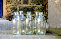 Five empty glass milk bottles on doorstep, Highbury, London Borough of Islington England UK