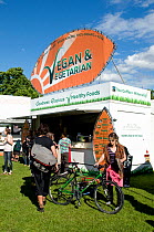 Vegan & Vegetarian Food Stall with people and a bicycle around, London Green Fair (previously Camden Green Fair) Regent&#39;s Park, England UK, June 2012