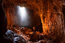 Potholer exploring the Graller del Boixaguer cave, Montsec mountains, Pyrenees, Catalonia, Spain, May 2012. Model released.