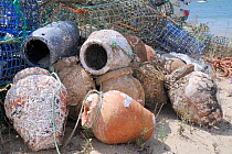 Stack of lobster pots and traditional ceramic Octopus pots encrusted with serpulid worm tubes and barnacles, Culatra island, Parque Natural da Ria Formosa, near Olhao, Algarve, Portugal, June.