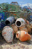 Stack of lobster pots and traditional ceramic Octopus pots encrusted with serpulid worm tubes and barnacles, Culatra island, Parque Natural da Ria Formosa, near Olhao, Algarve, Portugal, June.