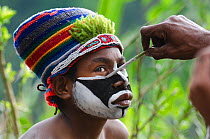 Western Highlanders preparing for a Sing-sing at the Paiya Show, applying face paint, Western Highlands near Mount Hagen, Papua New Guinea, August 2011