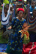Lady in market with male Raggiana Bird of Paradise (Paradisaea raggiana) for sale, Mount Hagen, Papua New Guinea, August 2011