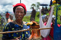 Lady in market with male Raggiana Bird of Paradise (Paradisea raggiana) for sale, Mount Hagen Papua New Guinea, August 2011
