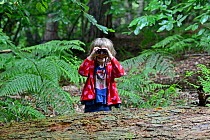 Young girl bird watching in woodland in summer Norfolk. July 2011. Model Released