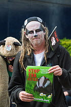 Man with Badger facepaint, holding leaflets which say 'Stop the cull', at anti bager cull march, 1st June 2013. Editorial use only