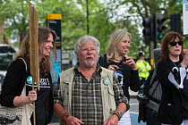 Naturalist and TV presenter Bill Oddie talking to a protestor holding a sign, at anti badger cull march, London 1st June 2013.