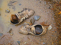Discarded shoes at construction site for road and associated infrastructure allowing access to previously isolated regions. African rainforest transport penetration in  Cameroon, Central Africa, Augus...