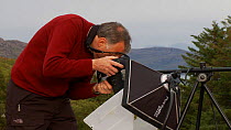 Photographer Niall Benvie using and talking about  his portable field studio set up whilst on assignment for 2020vision, Coigach / Assynt Scottish Wildlife Trust Reserve, Sutherland, Highlands, Scotla...