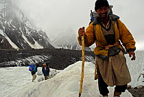 Three Balti porters on the Baltoro Glacier, Concordia, Central Karakoram National Park, Pakistan, July 2007.