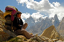 A Balti porter resting, with mountains in the background, Central Karakoram National Park, Pakistan, July 2007.