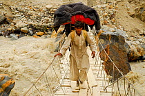 Balti porter crossing a rope bridge over the River Braldu, Braldu Valley, Karakoram Range, Pakistan, July 2007.
