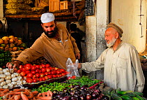 Man buying vegetables from a stall in Skardu bazaar, Pakistan, June 2007