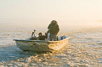 Photographers in a skiff along the coast during autumn freeze up, Beaufort Sea, off the 1002 area of the Arctic National Wildlife Refuge, North Slope, Alaska