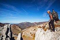 Hiker on limestone ridge in Mehedinti Plateau Geopark, Romania, October 2012