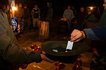 Romanian hunters participating in a lottery to share the freshly prepared meat of a female Wild boar (Sus scrofa) that was shot during a driving hunt. Mehadia, Caras Severin, Romania, October 2012