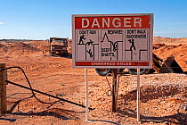 Sign warning visitors about the danger of mine shafts, Coober Pedy - a desert opal mining town, South Australia