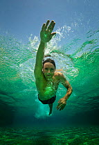 A boy swimming crawl stroke in a pool, Egypt, September 2012. Model released