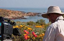 Cameraman Rod Clarke filming flowers for the Kalahari episode of the BBC series 'Africa', Namaqualand, South Africa, August 2012.