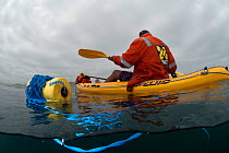 Man recreational fishing from a sea kayak for West coast rock lobster (Jasus lalandii) Kommetjie, Western Cape, South Africa