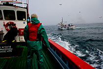 Fishing for West coast rock lobster (Jasus lalandii) aboard the James Archer (Oceana fisheries), crew member watching another boat, Saldanha Bay and St. Helena Bay, Western Cape, South Africa.
