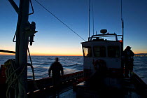 West coast rock lobster (Jasus lalandii) fishing boat James Archer (Oceana fisheries) leaves the St Helena Bay harbour before the break of dawn. St. Helena Bay, Western Cape, South Africa.