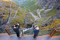 Tourists taking photographs from the The Trollstigen, of the National tourist road (Nasjonal turistveg) - Road 63, in Rauma, More og Romsdal, Norway.