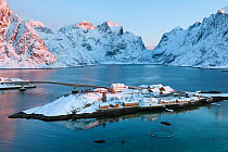 View of Sakrisoy fishing village, in the Kirkefjorden. Moskenes, Lofoten, Nordland, Norway. Fish farm pen in foreground