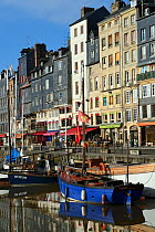 Honfleur harbour with boats and buildings reflected in the water, France, March 2013