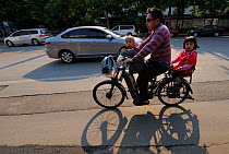 Man on bicycle commuting to work and the kids to school / daycare, Beijing, China