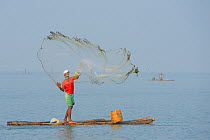 Throw-net fisherman, on raft, Pulicat Lake, Tamil Nadu, India, January 2013.