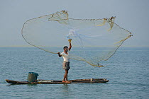 Throw-net fisherman, on raft, Pulicat Lake, Tamil Nadu, India, January 2013.
