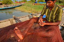 Fisherman mending the nets, Pulicat Lake, Tamil Nadu, India, January 2013.