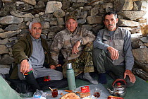 Two Tadjik guides and photographer Eric Dragesco, camping in stone house whilst searching for Himalayan Brown Bears (Ursus arctos isabellinus) Dashti Jum Reserve, Tadjikistan, April 2012