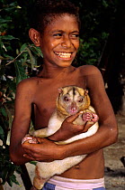 Boy with Eastern common cuscus (Phalanger intercastellanus) Fergusson island, Papua New Guinea.