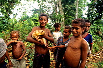 Boys with Eastern common cuscus (Phalanger intercastellanus) Fergusson island, Papua New Guinea.