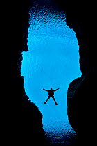 Diver swimming through Silfra Canyon, a deep fault filled with fresh water in the rift valley between the Eurasian and American tectonic plates, at Thingvellir National Park, Iceland. May 2011. In thi...
