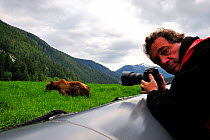 Photographer Eric Baccega photographing a Grizzly (Ursus arctos horribilis) from a zodiac boat, Khutzeymateen Grizzly Bear Sanctuary, British Columbia, Canada, June 2013.