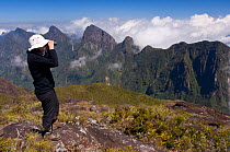Man enjoying the view from the peak of Marojejy Summit (2133m), Marojejy National Park, north eastern rainforest region, Madagascar.