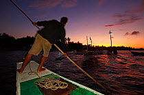 Man steering a bangka boat at sunset, Jao Island, Danajon Bank, Central Visayas, Philippines, April 2013