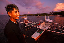 Portrait of man holding mooring rope of bangka boat, Jao Island, Danajon Bank, Central Visayas, Philippines, April 2013