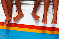 Children's feet hanging of a boat, Bilang Bilangang Island, Danajon Bank, Central Visayas, Philippines, April 2013
