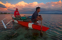 Fishermen departing in bangka boat at dusk, Batasan Island, Danajon Bank, Central Visayas, Philippines, April 2013